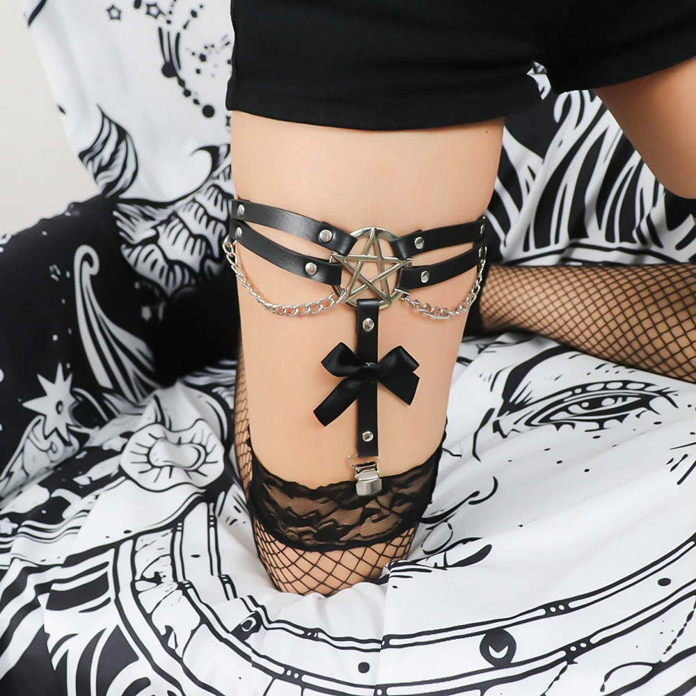 Black leather goth thigh harness with pentagram, chains, and bow detail, perfect for a bold BDSM look.
