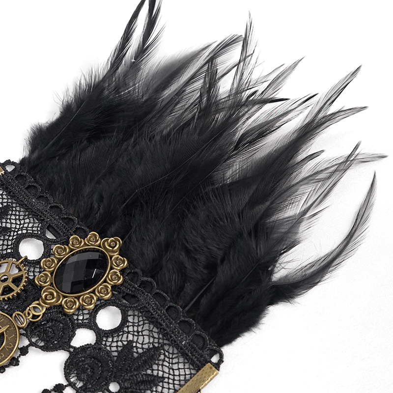 Luxurious black feather detail on gothic lace gloves with golden embellishments and a striking brooch.