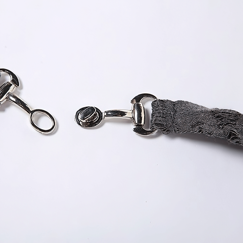 Close-up of silver metal clasps and a gray fabric strap, showcasing stylish details for accessories.