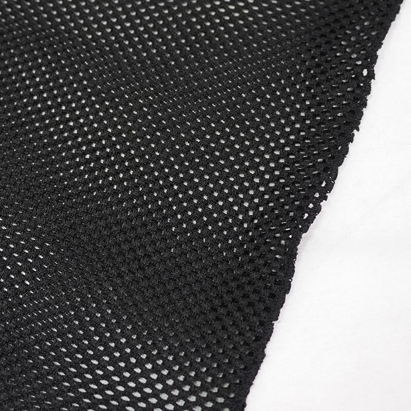 Close-up of black mesh fabric showcasing unique textured design for gothic-style dresses.