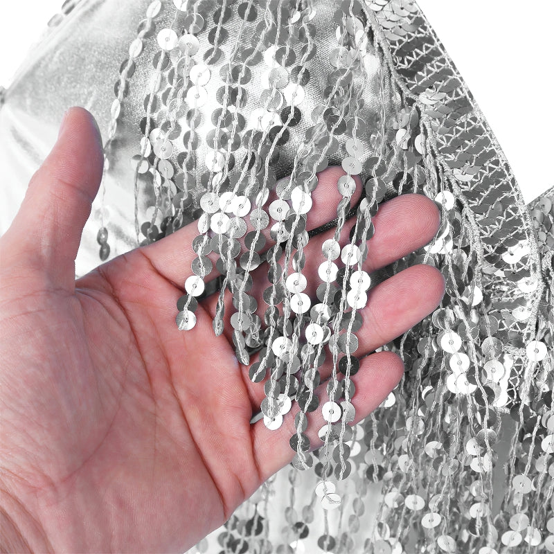 Close-up of hand holding shiny silver sequins on a stylish belly dance crop top, showcasing vibrant details.
