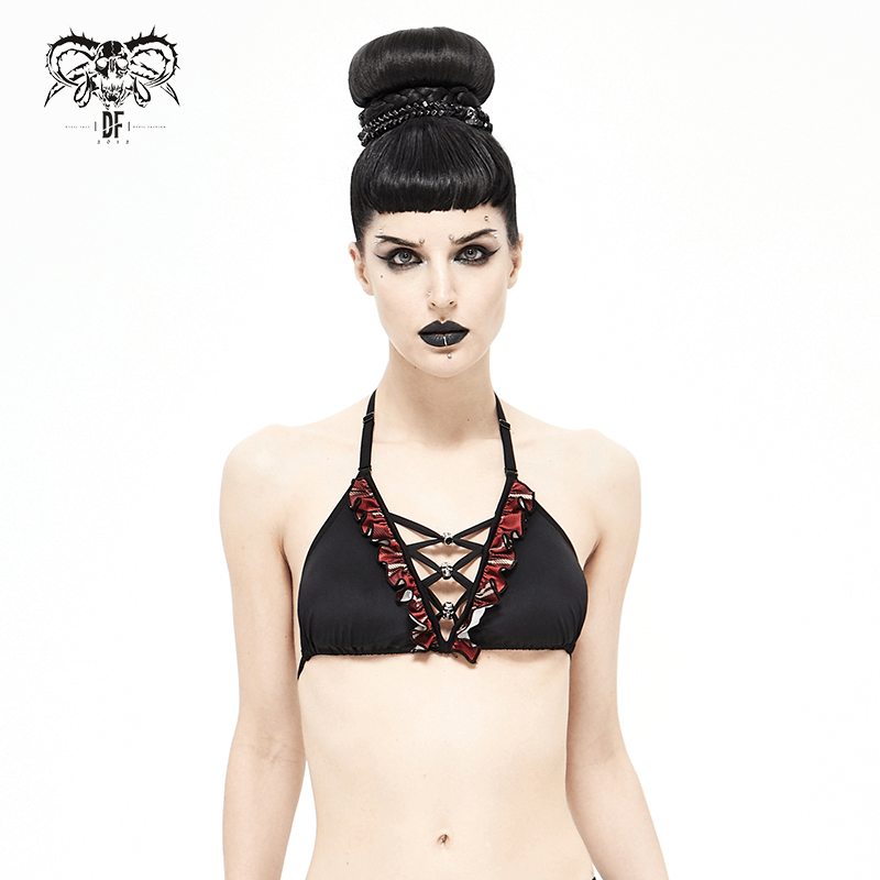 Fashionable model in a black and red plaid grunge bikini top with skull pendants, showcasing edgy swimwear style.
