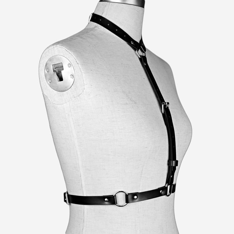 Stylish women's black leather body harness, perfect for goth and alternative fashion, featuring adjustable straps and metal rings.