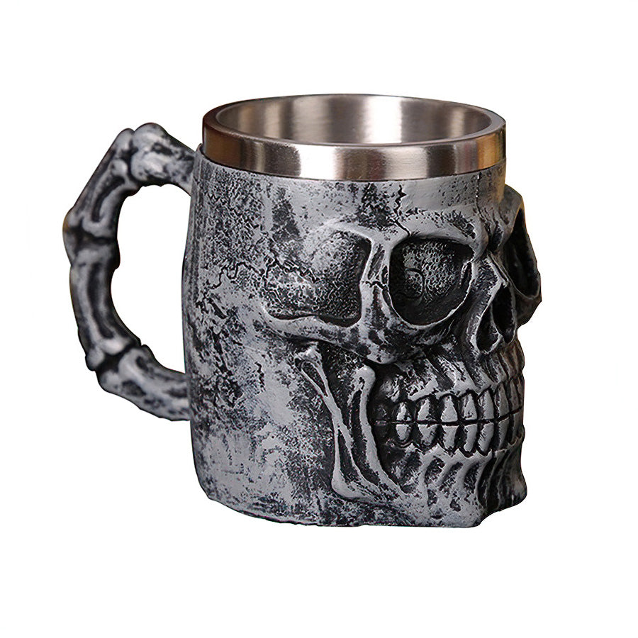 Silver skull mug with bone-shaped handle, perfect for gothic fashion lovers and retro Viking pub vibes.
