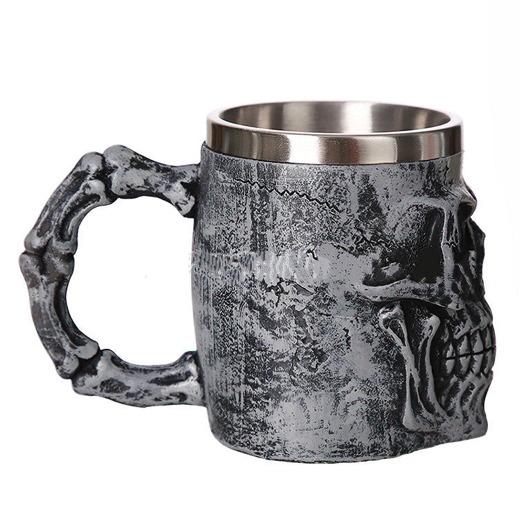 Silver skull mug with bone-shaped handle, perfect for gothic lovers; ideal for beer and unique gifts.