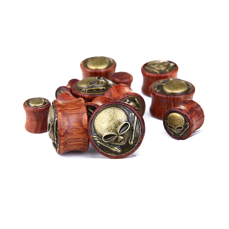 Wooden tunnel expanders with alien designs - trendy gauges for a unique ear jewelry look.
