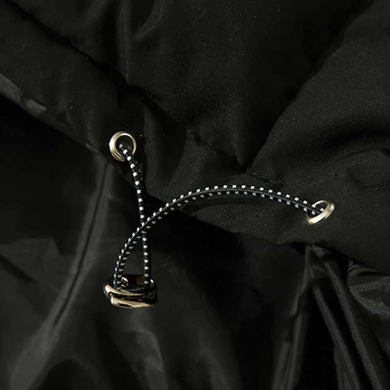 Close-up of black hooded jacket drawstring and fastener, perfect for punk fashion and stylish warmth.