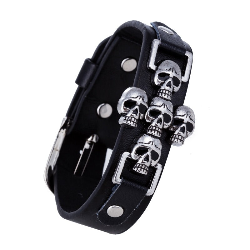 Stylish black leather bracelet with metallic skulls, perfect for punk and gothic fashion enthusiasts.