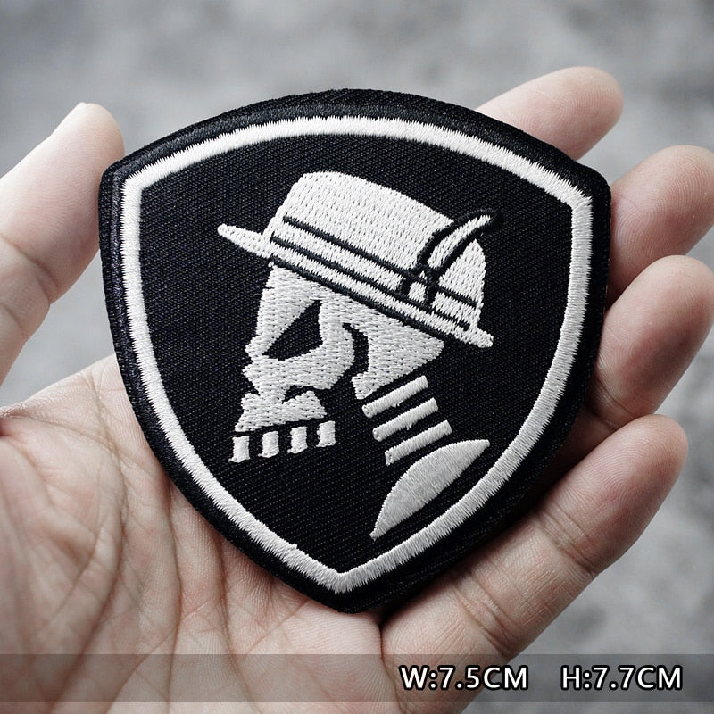 Skull and hat fusible patch held in hand, perfect for jackets and bags, stylish rock accessory.