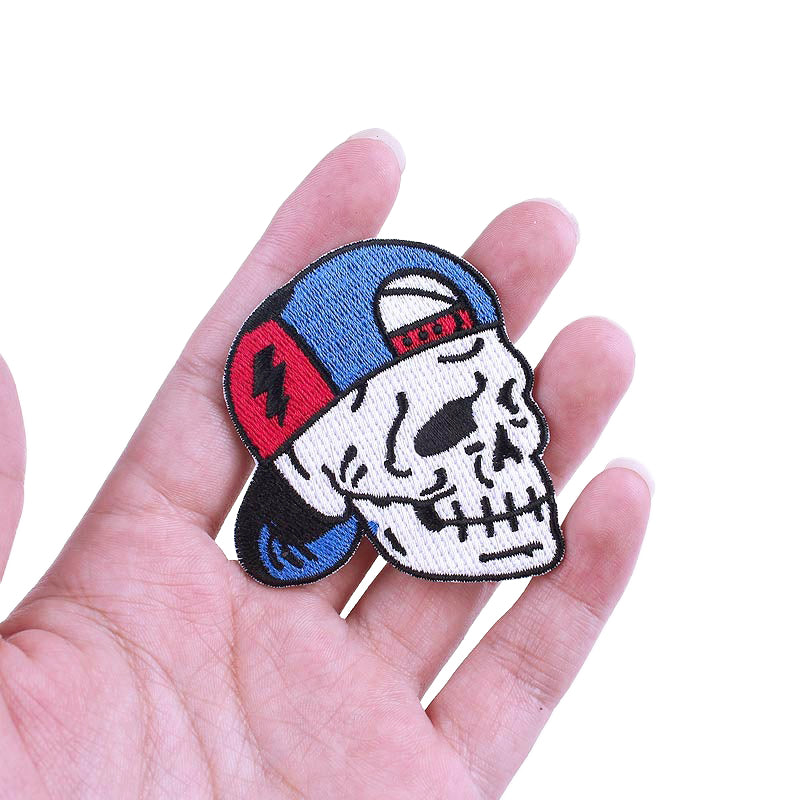 Skull patch with blue baseball cap held in hand, perfect for jackets and bags to enhance your rock style.