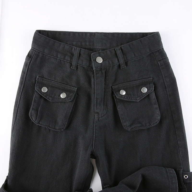 Close-up of women's black gothic pants with skull print and silver detailing, featuring high waist and large pockets.