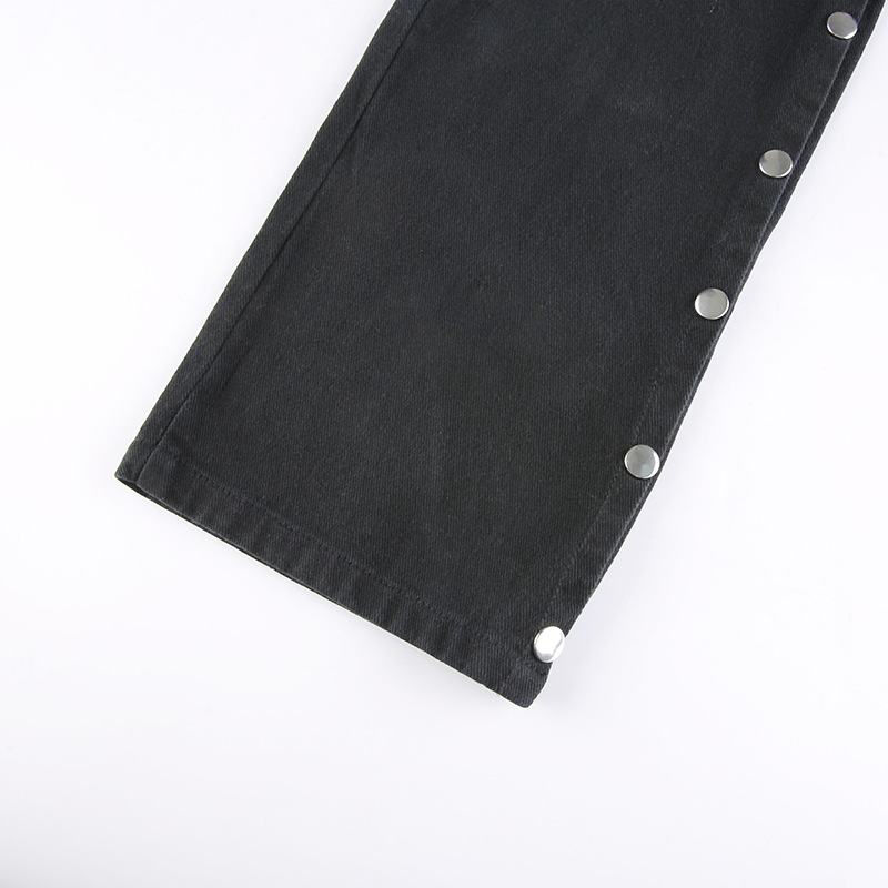 Close-up of women's black gothic pants showcasing silver buttons and stylish high-waist cut.