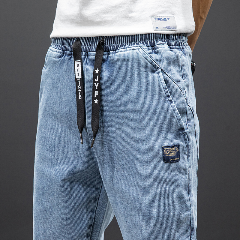 Men's denim cargo pants with elastic waistband and drawstrings in light blue.