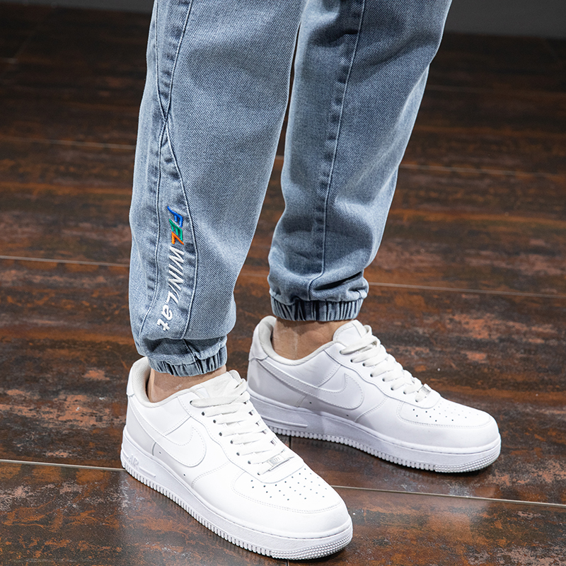 Men's denim cargo pants with elastic cuffs, paired with stylish white sneakers, perfect for casual outings.