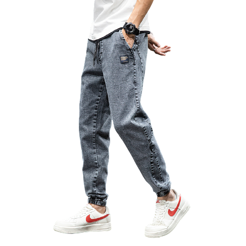 Men's denim cargo pants in casual style, featuring an elastic waistband and loose fit, paired with sneakers.