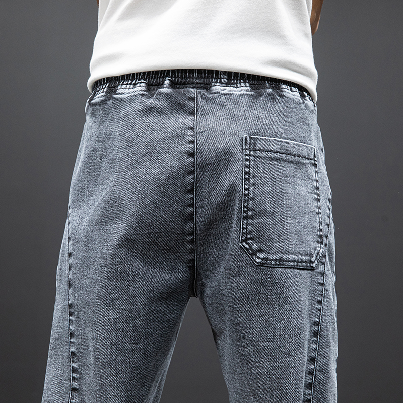Back view of men's denim cargo pants with elastic waistband and pocket detail, perfect for casual comfortable wear.