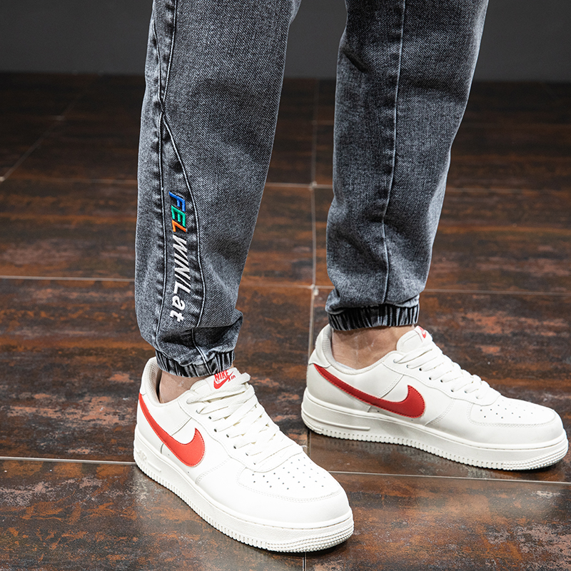 Men's denim cargo pants with elastic cuffs and a casual style, paired with white Nike sneakers.