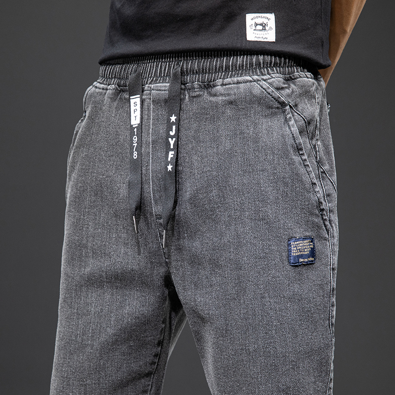 Men's denim cargo pants featuring a loose fit, elastic waistband, and stylish detailing in a gray color.
