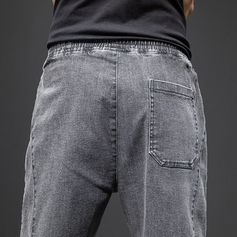 Men's denim cargo pants featuring an elastic waistband and side pocket in a casual style.