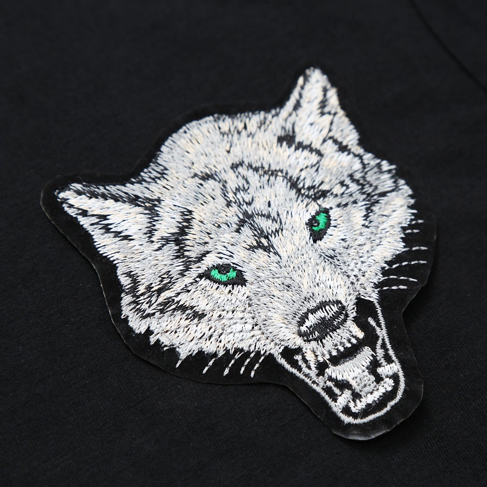 Close-up of embroidered wolf design on a black slim cotton t-shirt for men.