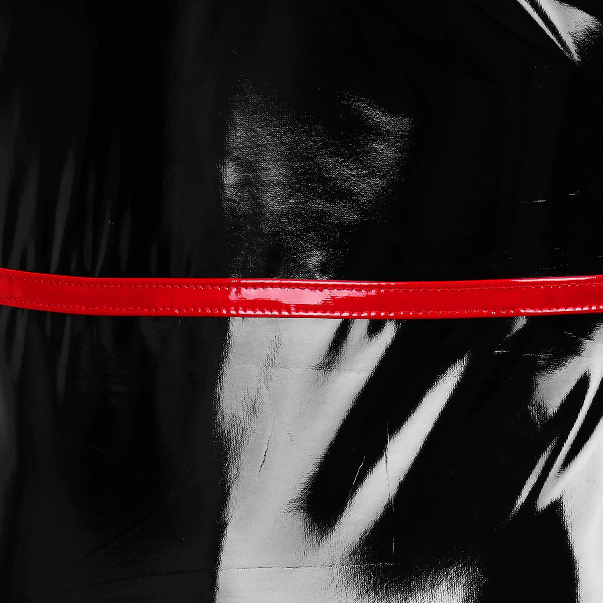 Close-up of a slim fit bodycon dress featuring glossy black fabric and a striking red accent band.