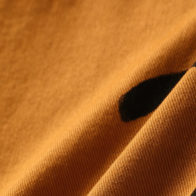 Close-up of soft cotton fabric featuring a smiley print, ideal for casual men's shirts.