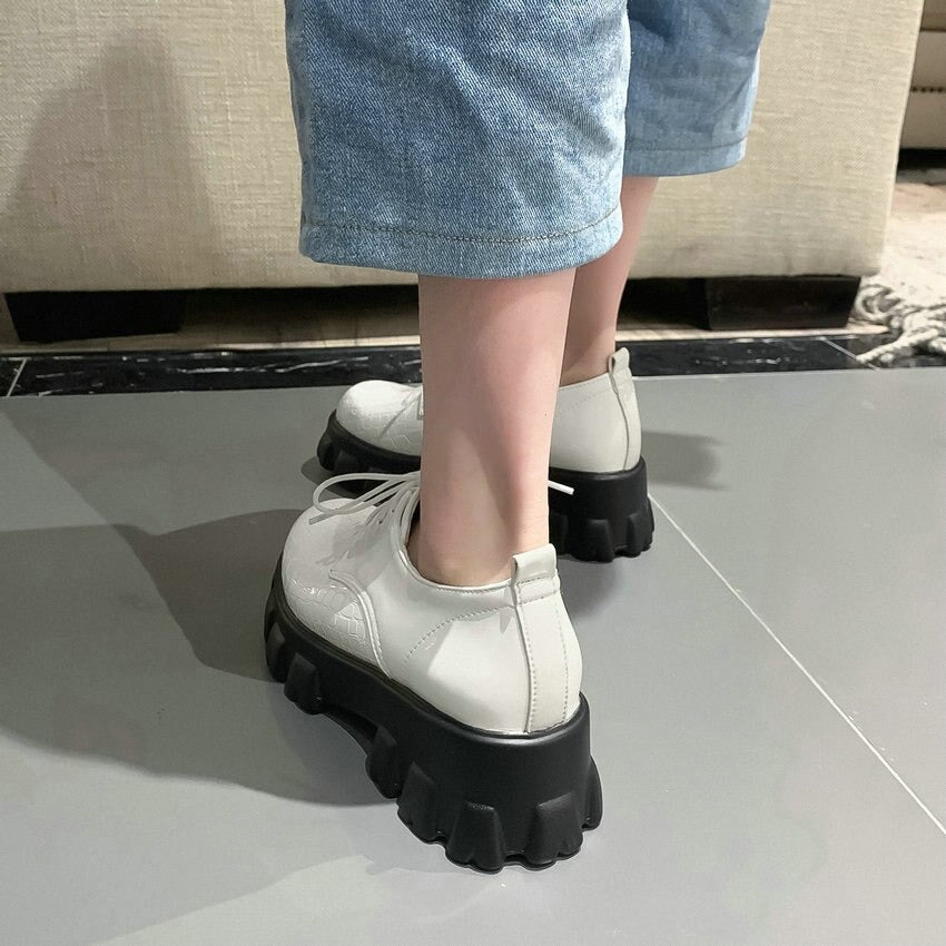 White lace-up chunky sneakers with black sole, stylish and trendy footwear for casual outings.