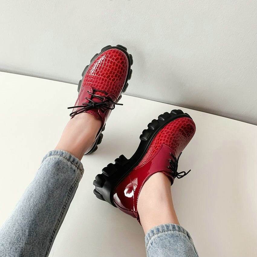 Stylish red snake pattern pumps with square high heels, lace-up design, and chunky rubber sole for a bold look.