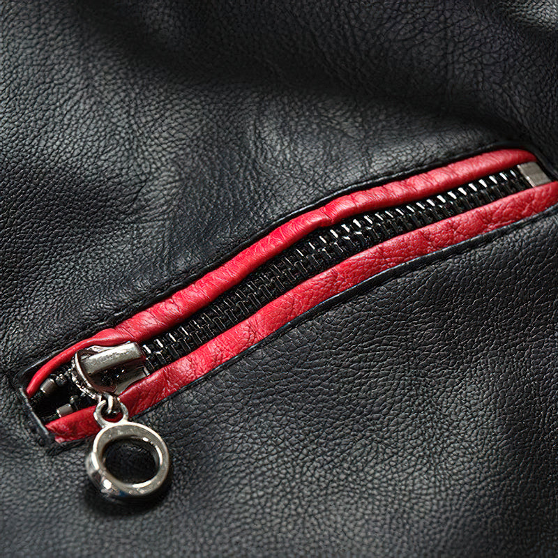 Close-up of black faux leather jacket zipper with red detailing for a stylish biker look.