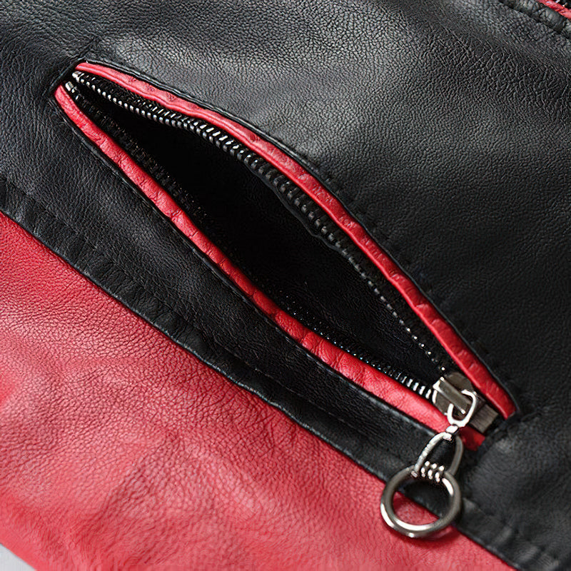 Close-up of spliced faux leather jacket zipper, showcasing red and black patchwork design and stylish biker details.