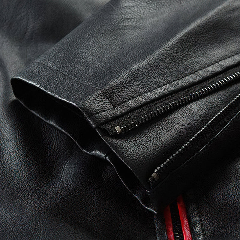 Close-up of black spliced faux leather jacket sleeve with zipper, showcasing its patchwork design and quality.