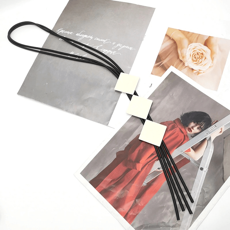 Stylish square wood pendant necklace for women with elastic rubber long straps on a stylish backdrop.