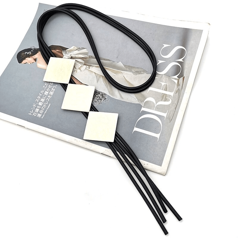 Square wood pendant necklace for women on a fashion magazine, showcasing casual style and unique design.