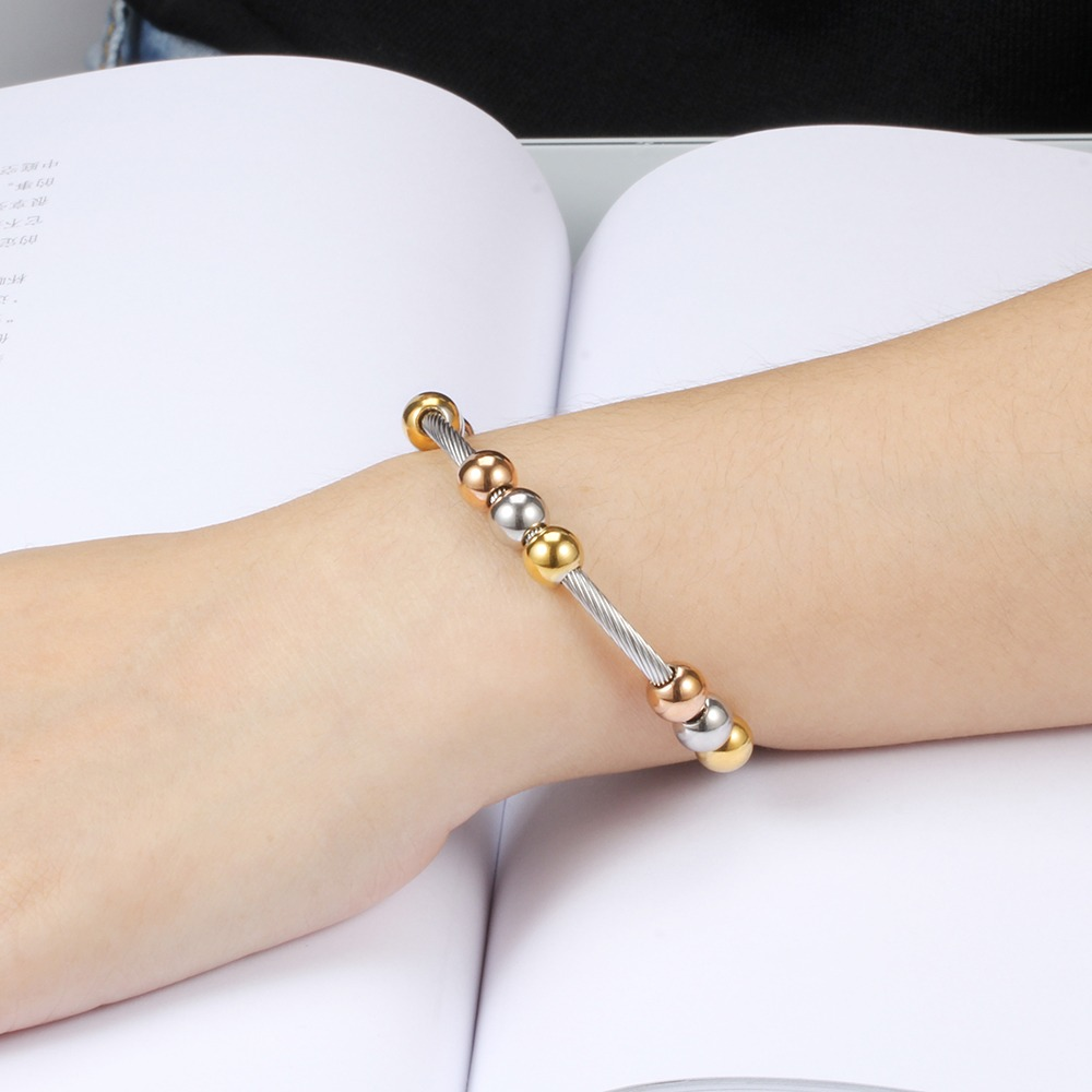 Stylish stainless steel bracelet in gold and silver, featuring round elements for a trendy look.