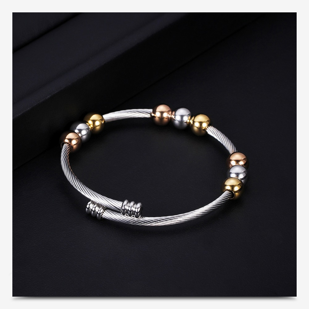 Stylish stainless steel bracelet in gold and silver tones with round elements, perfect for trendy women's accessories.