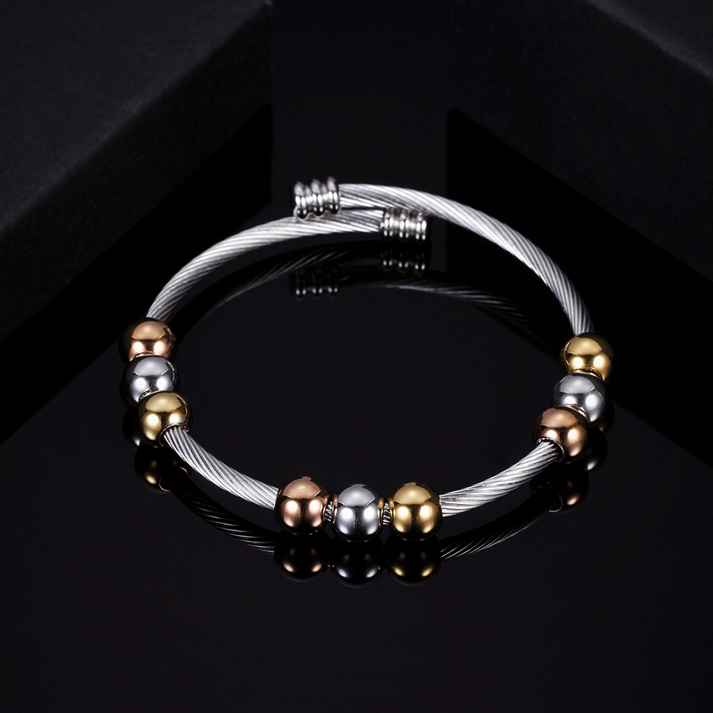 Trendy stainless steel bracelet in silver and gold with round elements, perfect for stylish women.