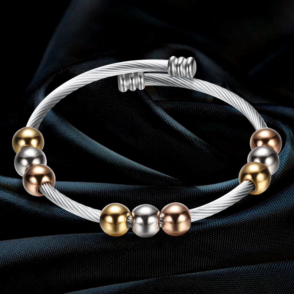 Trendy stainless steel bracelet in gold and silver color, featuring round elements for a stylish look.