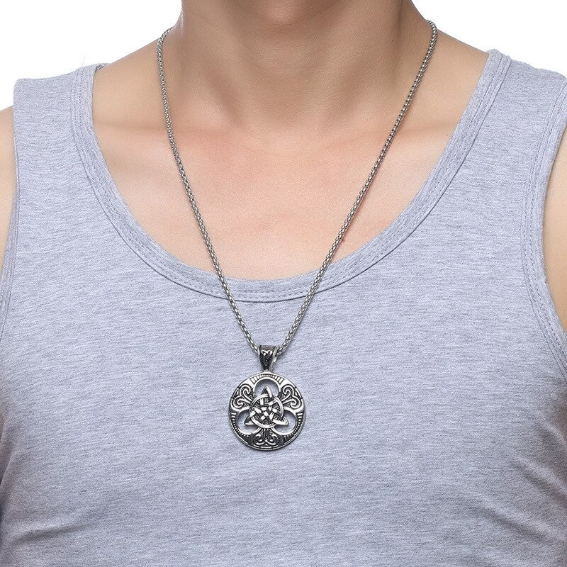 Man wearing a vintage stainless steel Celtic knot pendant with chain on grey tank top.