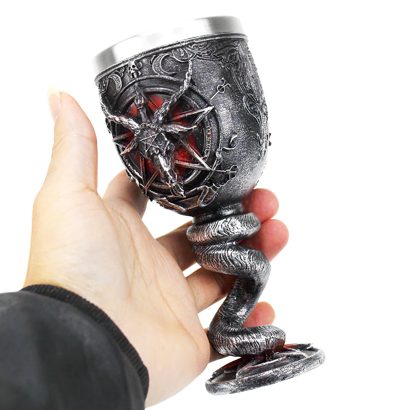 Hand holding a Gothic stainless steel drinkware cup with a pentagram design and snake-shaped base.
