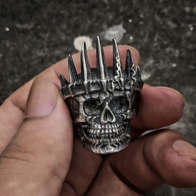 Hand holding a stainless steel gothic skull ring with spikes, perfect unisex jewelry for skull lovers.