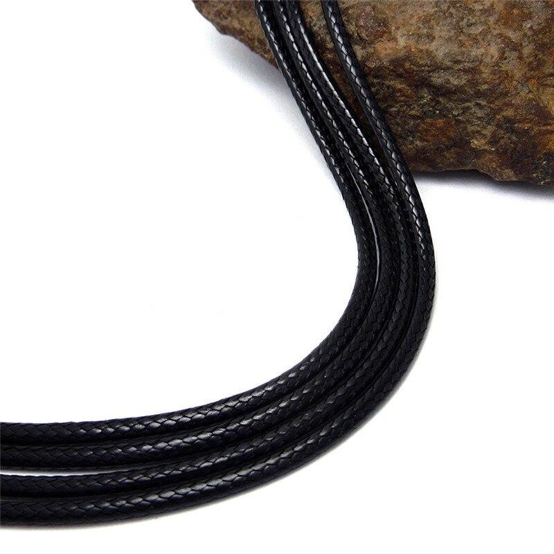 Black wax rope necklace resting on a rock, showcasing its sleek texture and stylish versatility for any outfit.