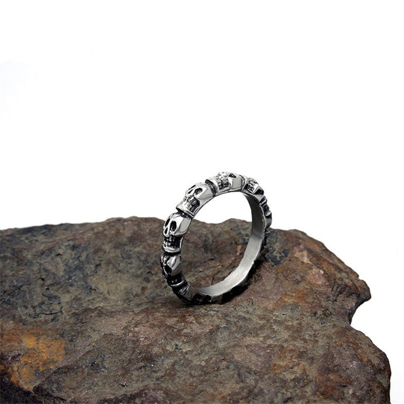 Stainless steel skull ring on a rock surface, showcasing a unique punk design for men and women.