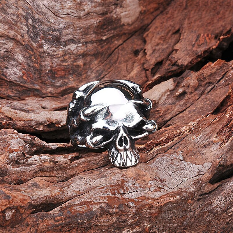 Stainless steel skull ring with claw design on wooden surface, perfect for rock style and biker jewelry.