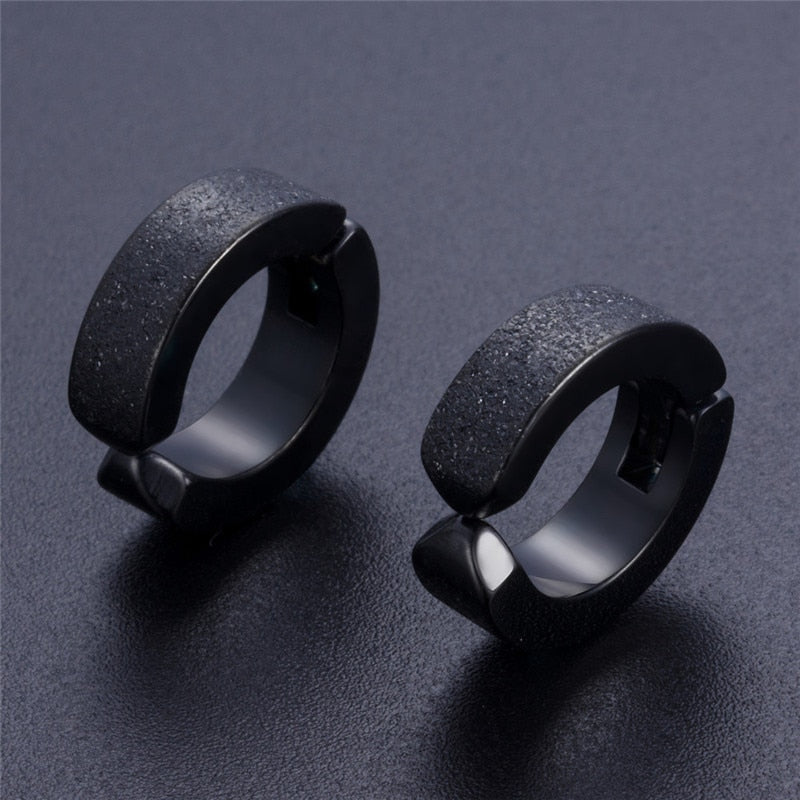 Stylish black stainless steel hoop earrings with a textured finish, perfect for alternative fashion enthusiasts.