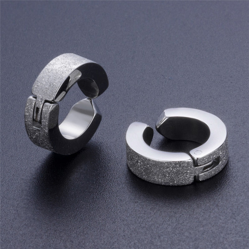 Stylish stainless steel huggie earrings with a shiny and textured finish, perfect for alternative fashion enthusiasts.