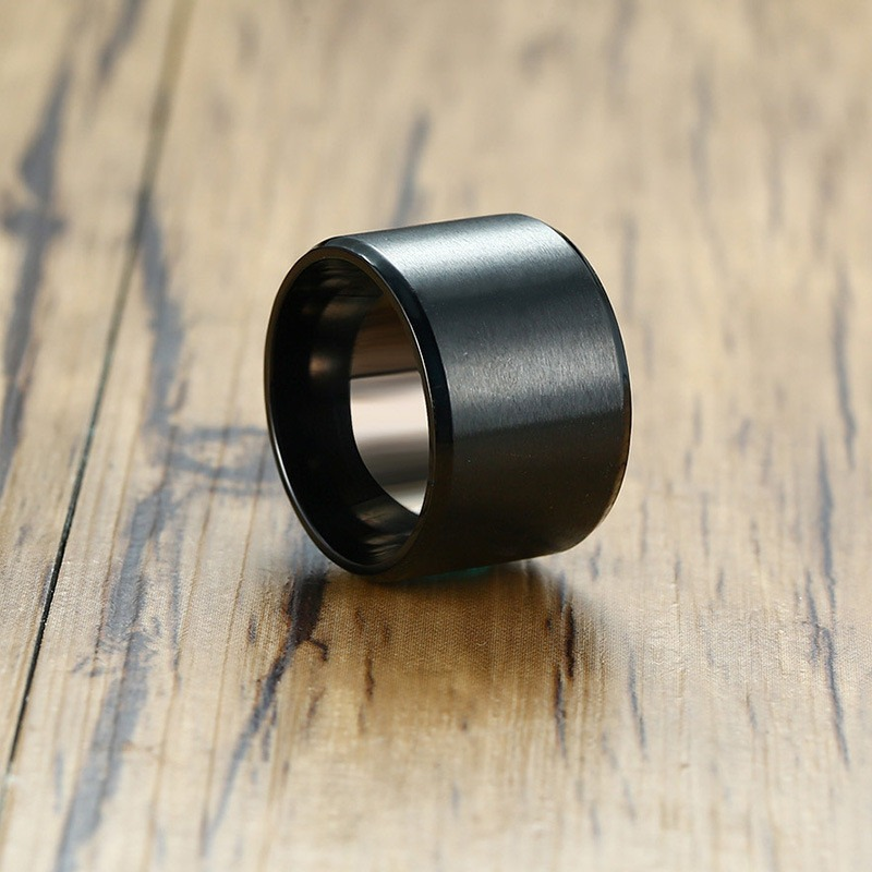 Black stainless steel unisex bulky ring on wooden surface, ideal for gothic and casual styles.