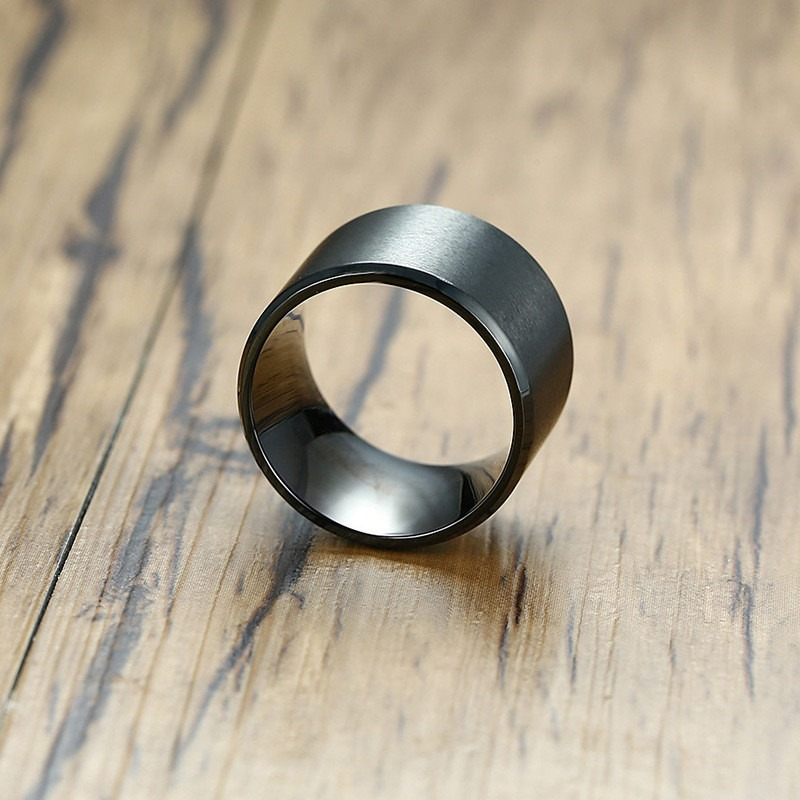 Stainless steel unisex black bulky ring on wooden surface, perfect for gothic and casual styles.
