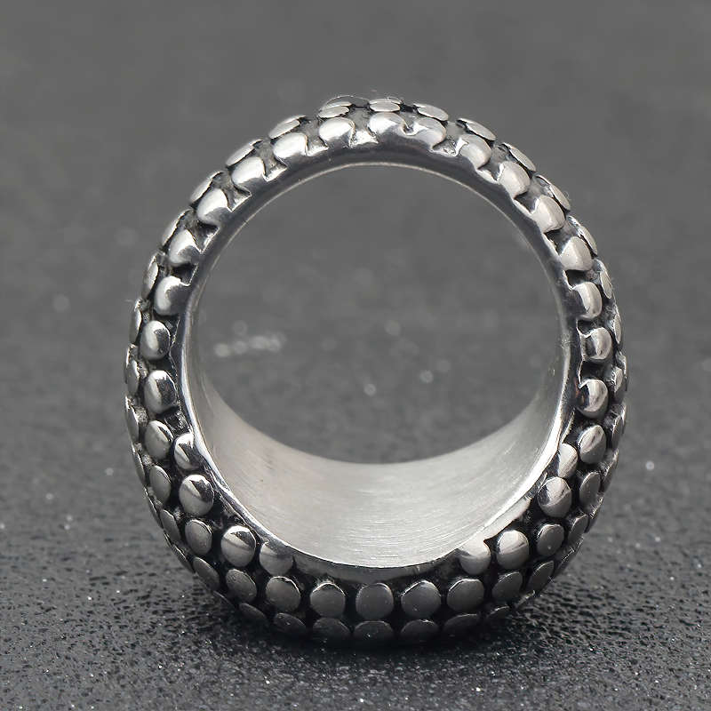Close-up of a vintage stainless steel unisex ring with a textured outer design, perfect for men and women.