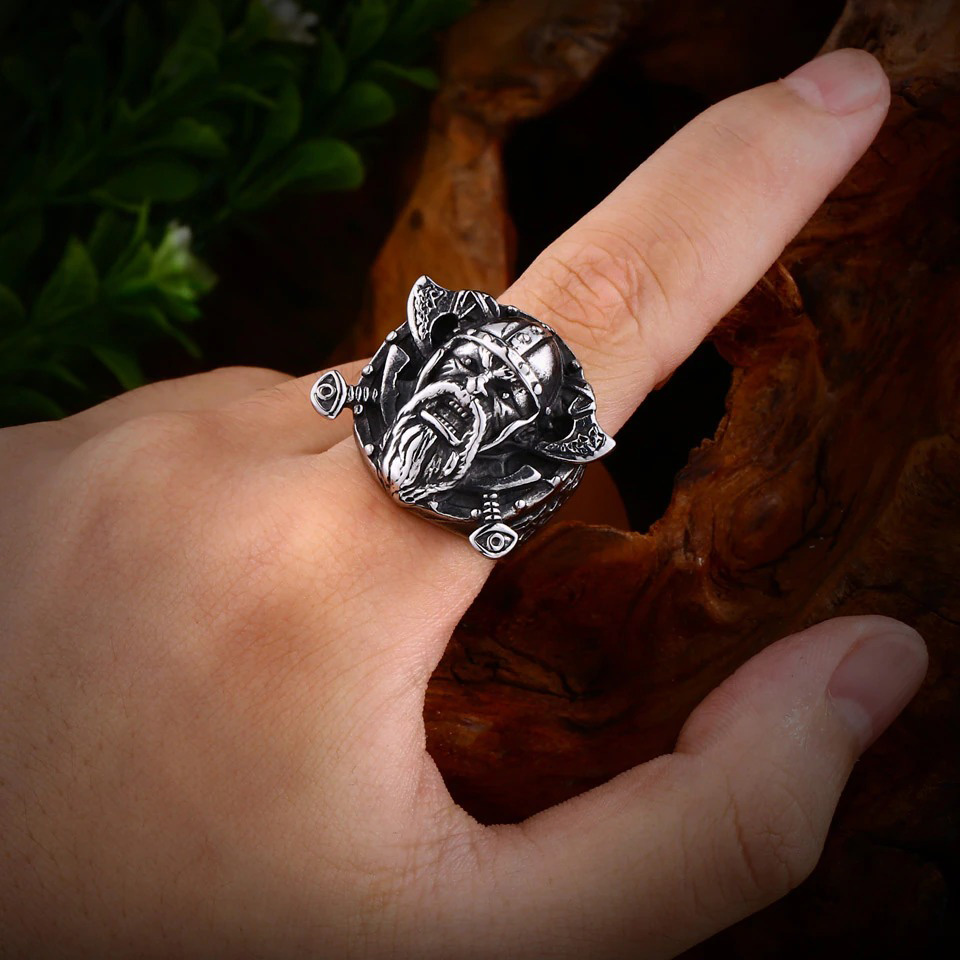 Stainless steel Viking ring featuring Odin's shield, vintage design worn on a finger against a wooden backdrop.