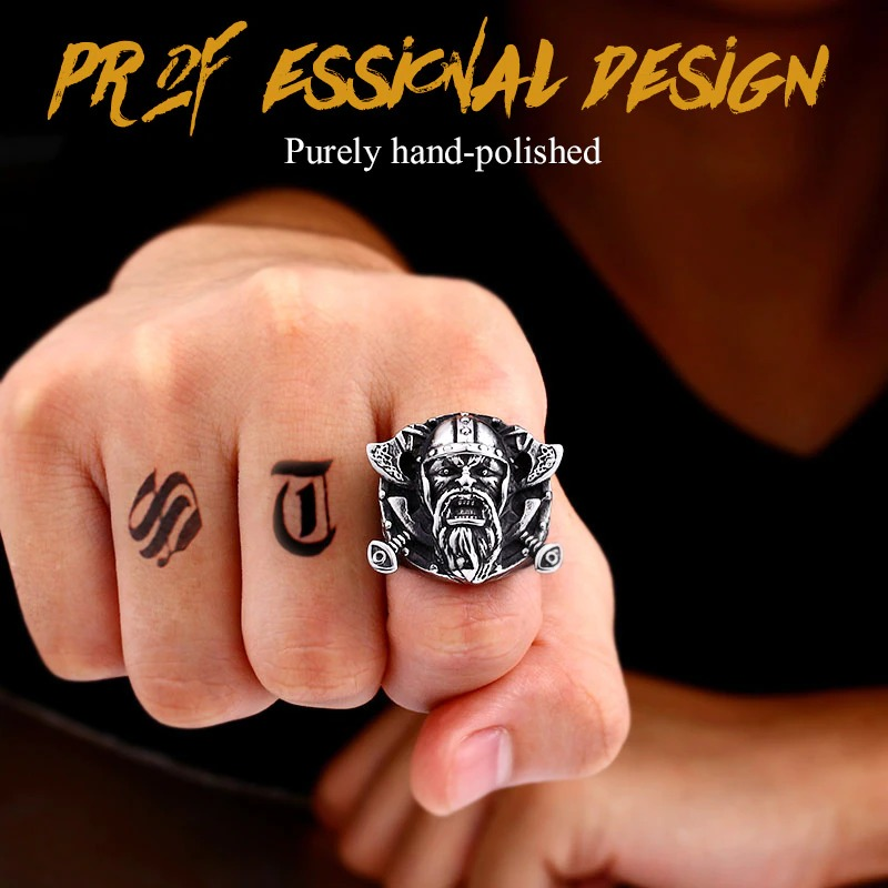 Stainless steel Viking ring with Odin's shield, showcasing a fierce face design and hand-polished finish on a tattooed hand.
